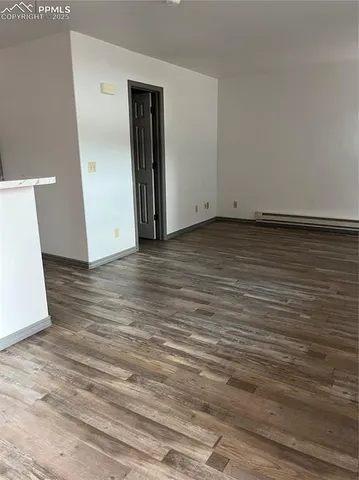 a view of an empty room with wooden floor