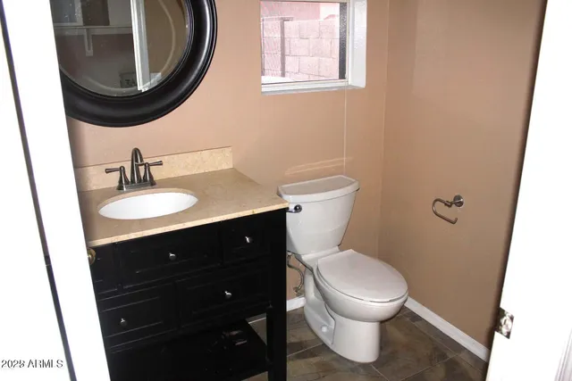 a bathroom with a toilet a sink and a mirror