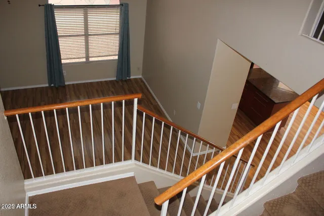a view of staircase with railing and a window