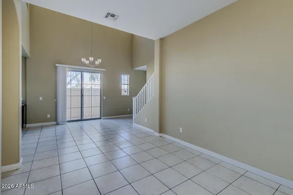a view of an empty room with window and stairs