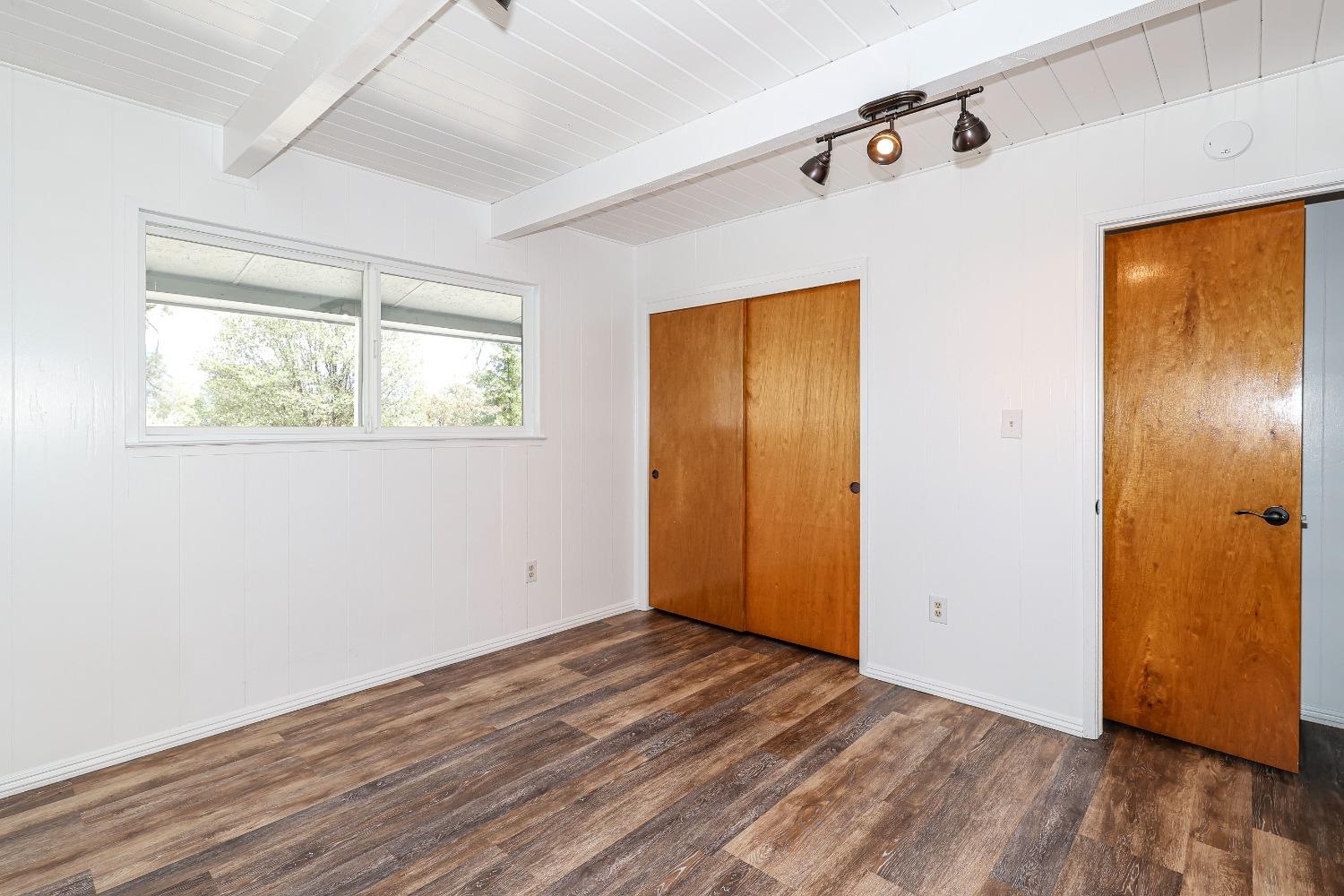 5240 Tiptop Road Mariposa, CA 95338 - Photo 27 of 71 a view of an empty room with wooden floor and a window