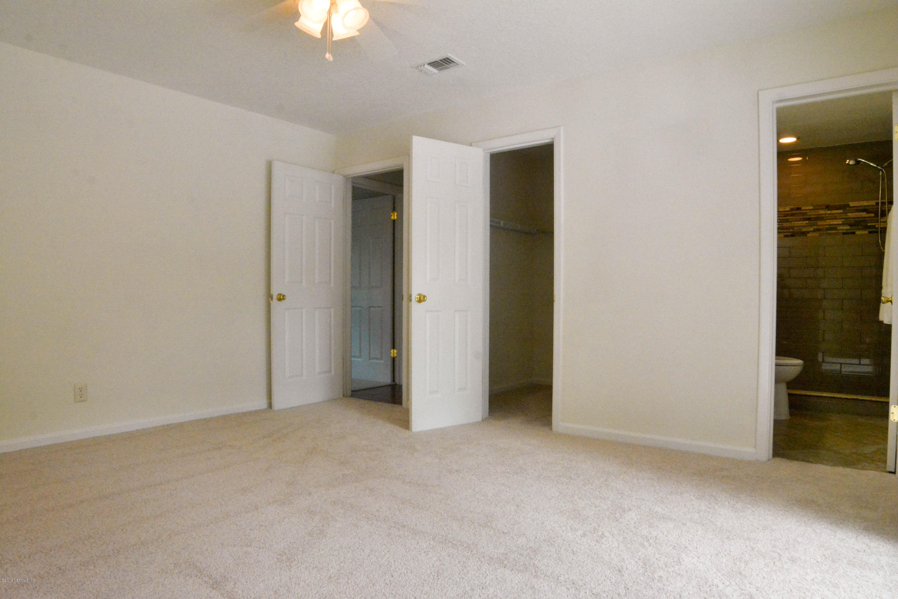 6717 West Fincannon Road Jacksonville, FL 32277 - Photo 23 of 32 an empty room with closet and a chandelier fan