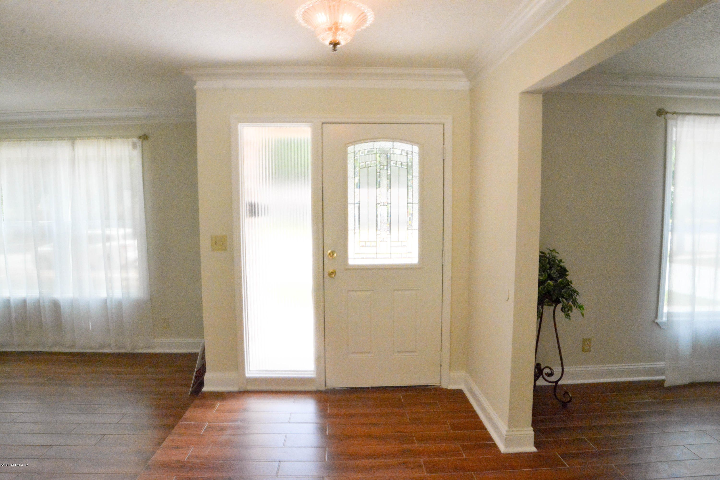 6717 West Fincannon Road Jacksonville, FL 32277 - Photo 4 of 32 an empty room with wooden floor and windows