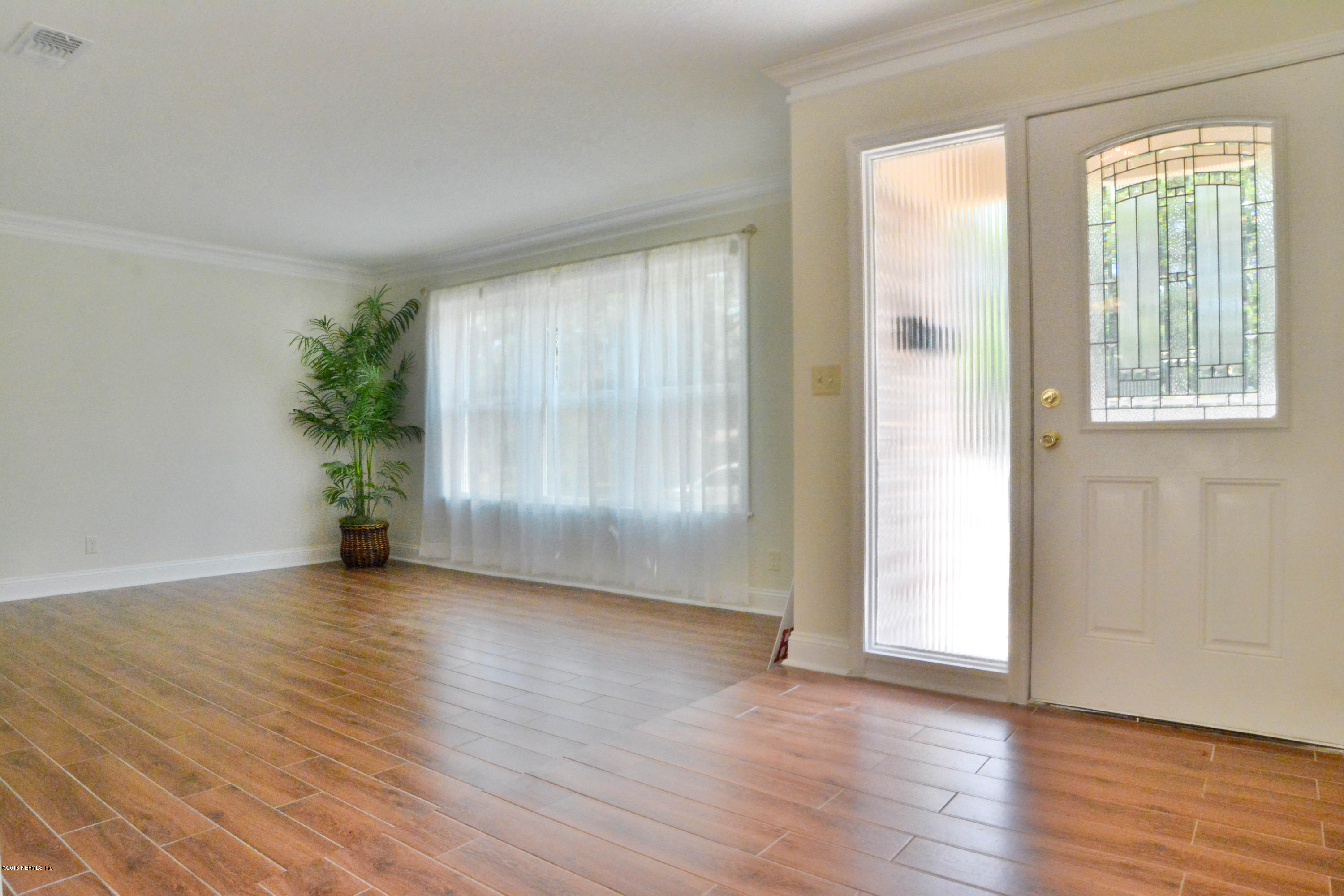 6717 West Fincannon Road Jacksonville, FL 32277 - Photo 5 of 32 a view of an empty room with wooden floor and a window