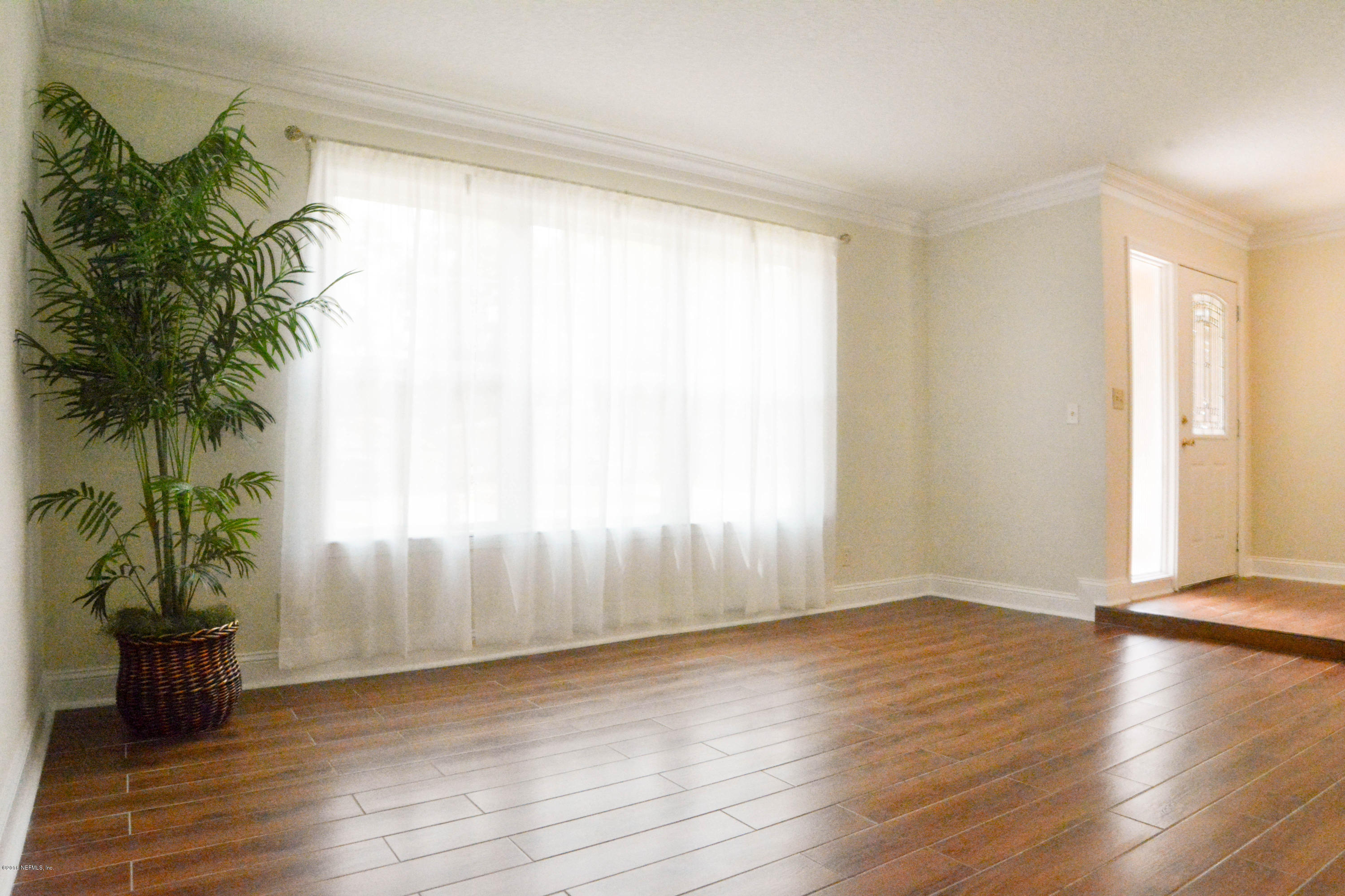 6717 West Fincannon Road Jacksonville, FL 32277 - Photo 7 of 32 a view of a room with wooden floor and a window