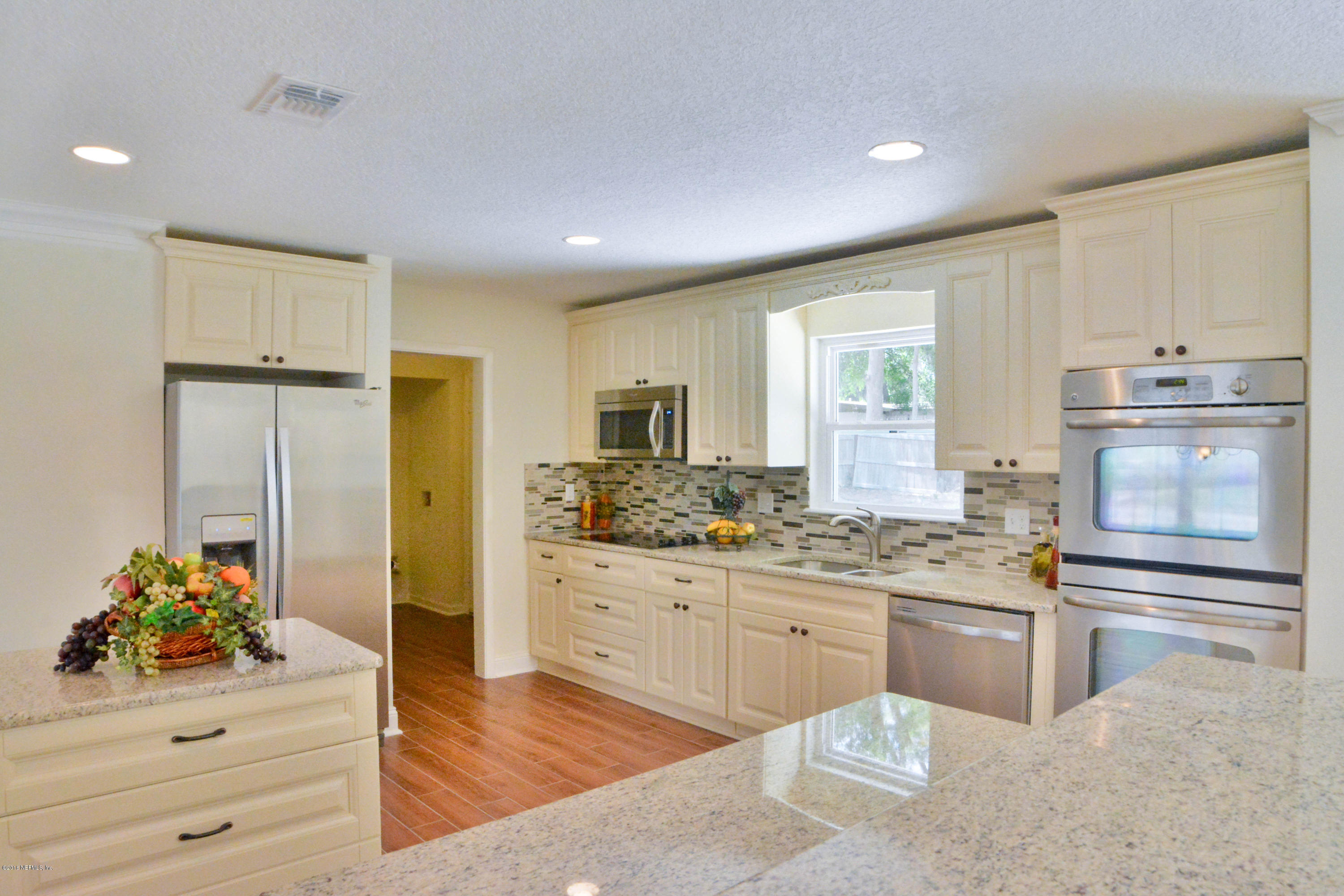 6717 West Fincannon Road Jacksonville, FL 32277 - Photo 10 of 32 a kitchen with stainless steel appliances kitchen island granite countertop a sink and cabinets