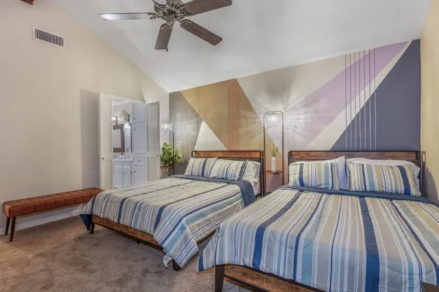 a bedroom with two beds and a chandelier