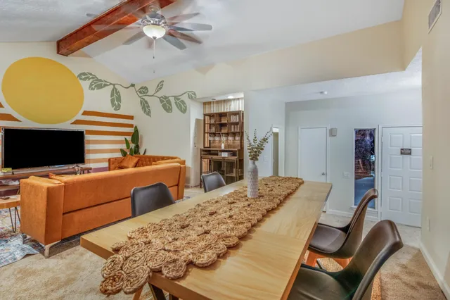 a bedroom with a bed and dresser with wooden floor
