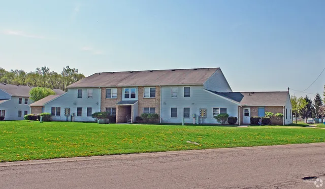 a view of a big house with a big yard and large trees
