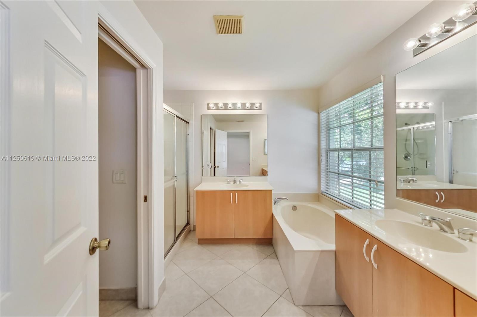 Silver Falls Miramar, FL 33027 - Photo 18 of 38 a spacious bathroom with a double vanity sink a mirror and a bathtub