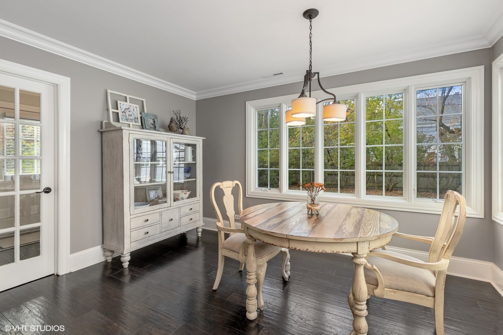 1414 North Avenue Bannockburn, IL 60015 - Photo 10 of 29 a dining room with wooden floor a chandelier a glass table and chairs