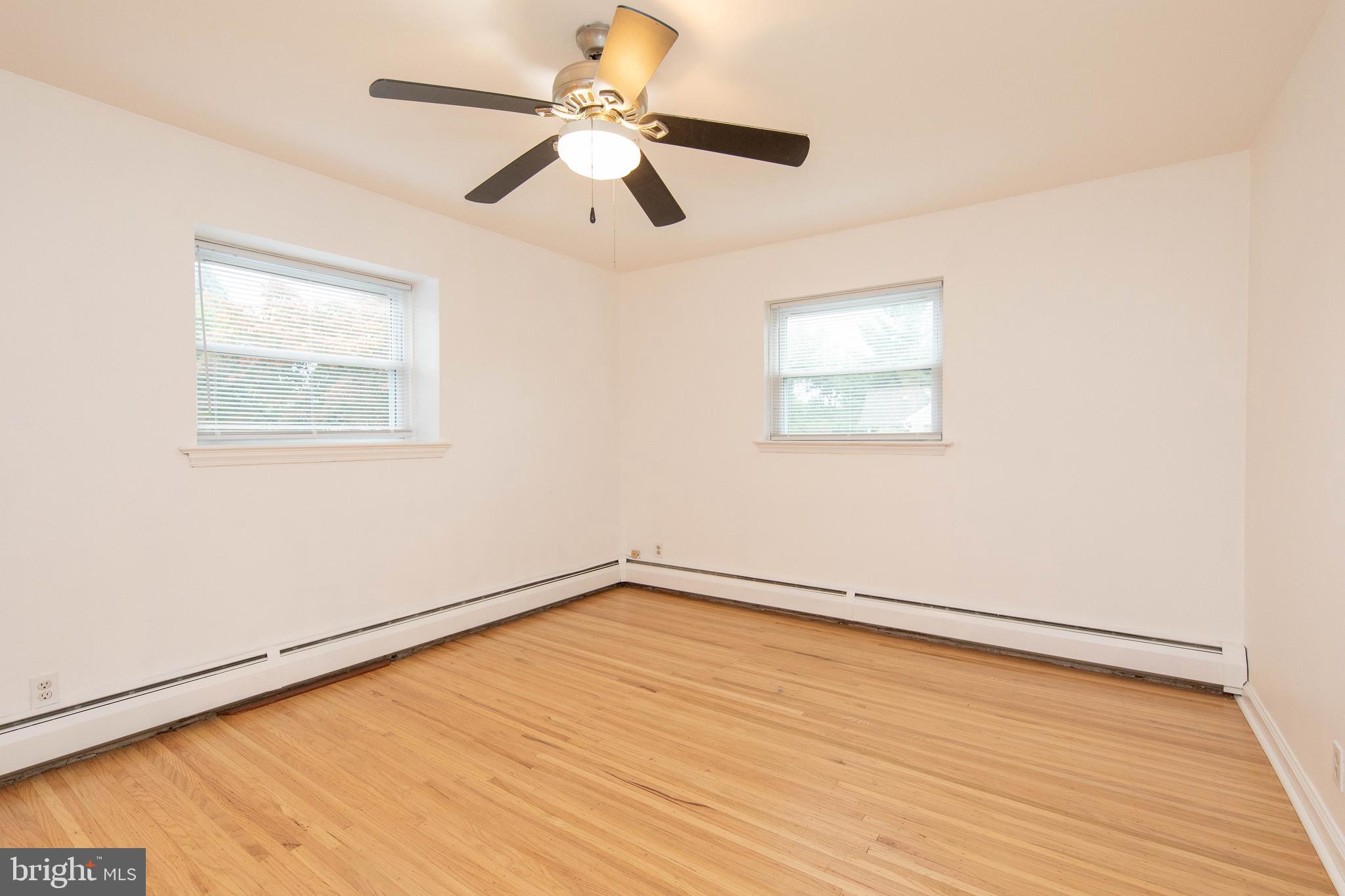 95 Radburn Road Huntingdon Valley, PA 19006 - Photo 18 of 40 an empty room with wooden floor fan and windows