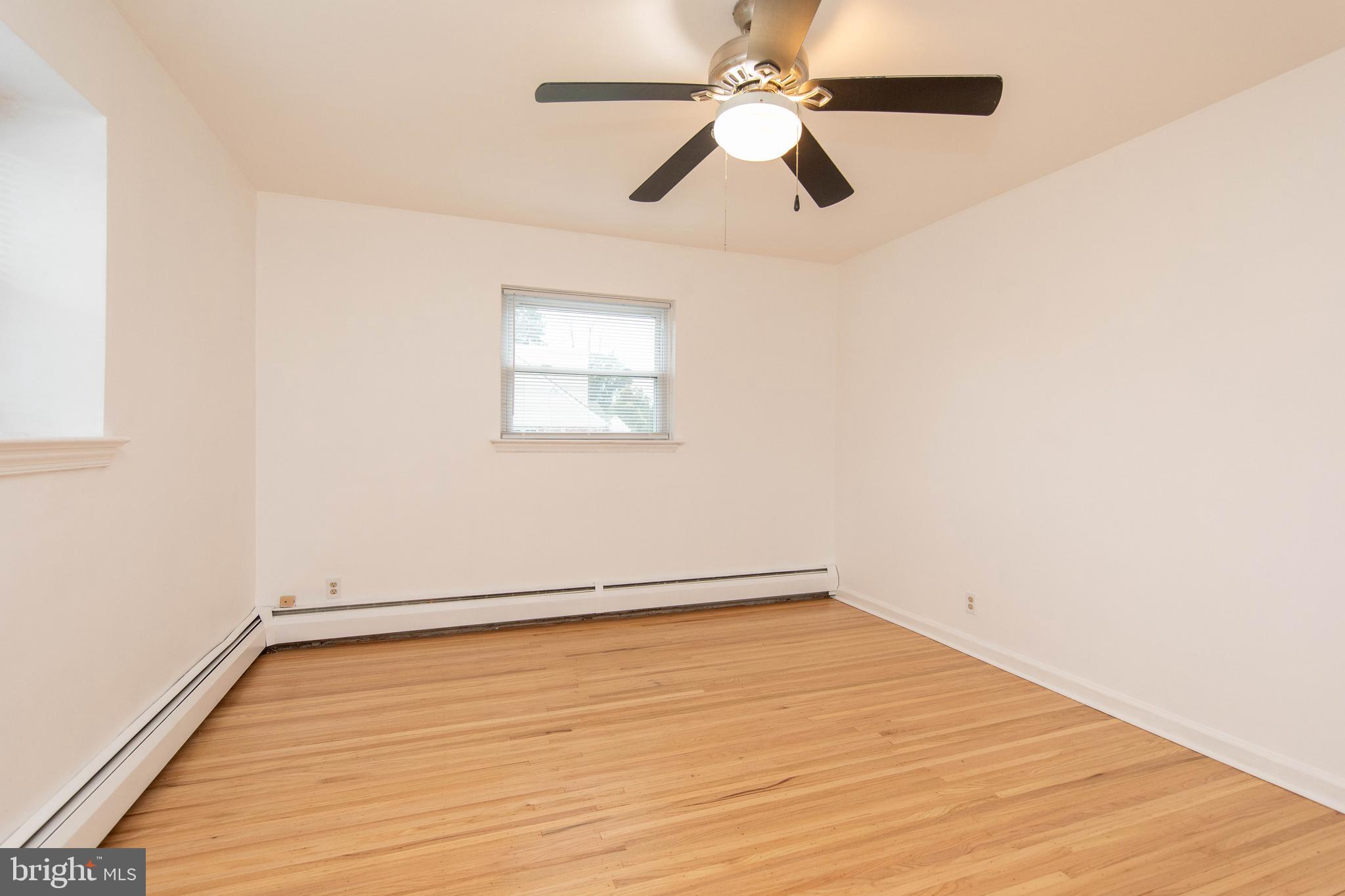 95 Radburn Road Huntingdon Valley, PA 19006 - Photo 20 of 40 an empty room with wooden floor fan and windows