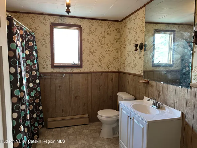 a bathroom with a sink a toilet and mirror
