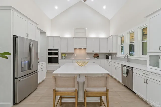 a kitchen with refrigerator a sink and chairs