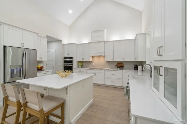 a kitchen with white cabinets and stainless steel appliances