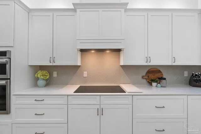 a kitchen with white cabinets and appliances