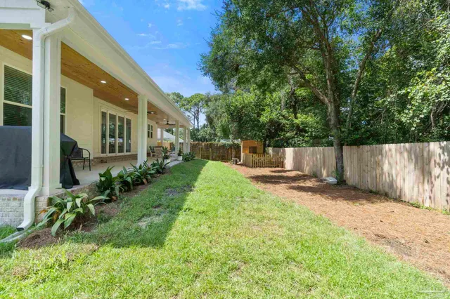 a view of a patio with couches and table and chairs with wooden floor and fence