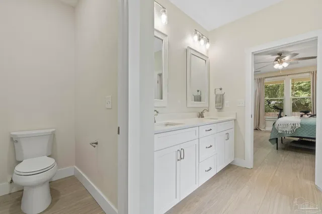 a spacious bathroom with a toilet a sink and a mirror