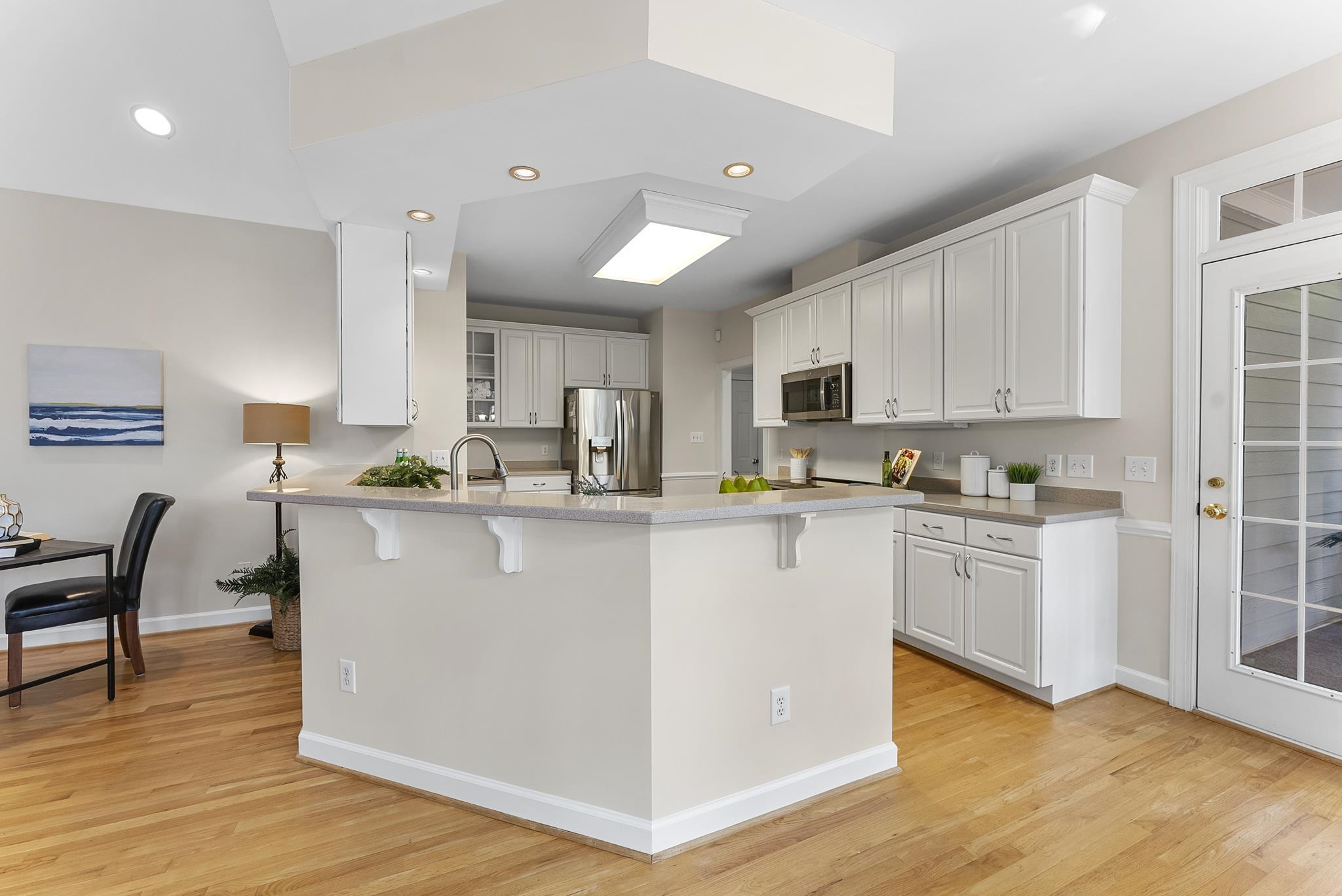 1608 Falls River Avenue Raleigh, NC 27614 - Photo 14 of 65 a kitchen with stainless steel appliances granite countertop a stove top oven a sink a refrigerator white cabinets and wooden floor