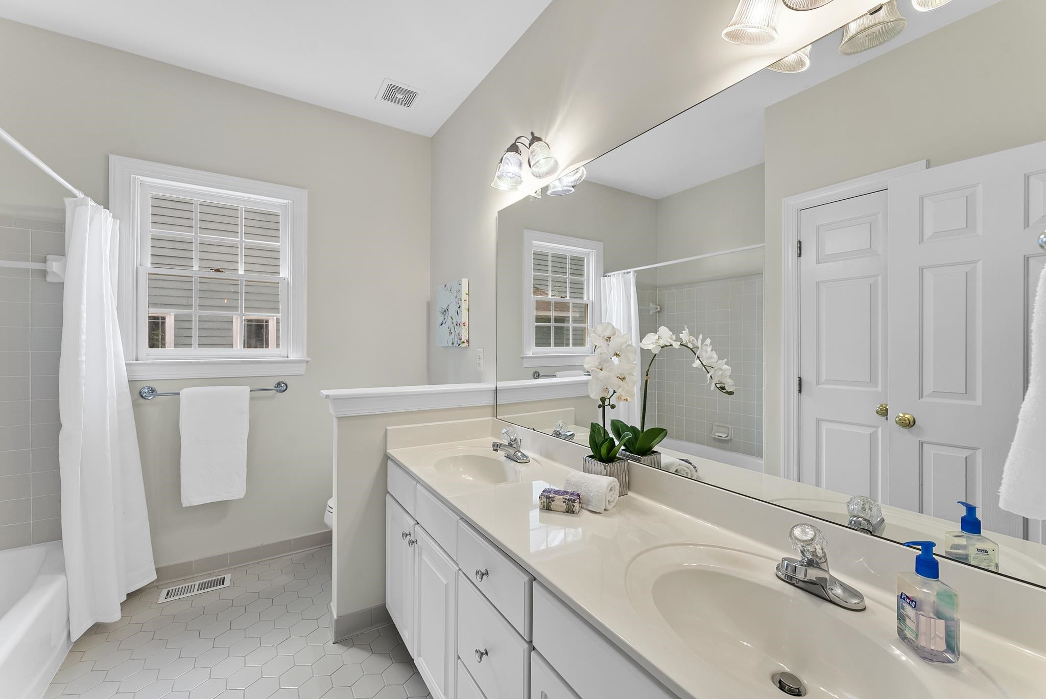 1608 Falls River Avenue Raleigh, NC 27614 - Photo 26 of 65 a bathroom with double vanity and a mirror