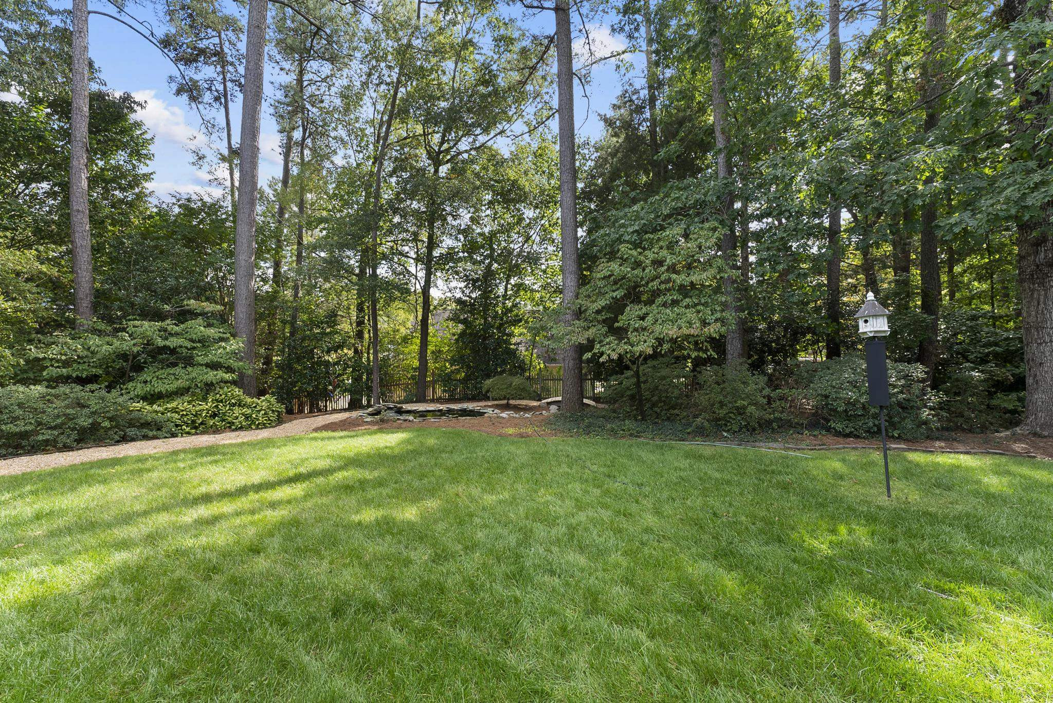 1608 Falls River Avenue Raleigh, NC 27614 - Photo 39 of 65 a view of a grassy field with trees in the background