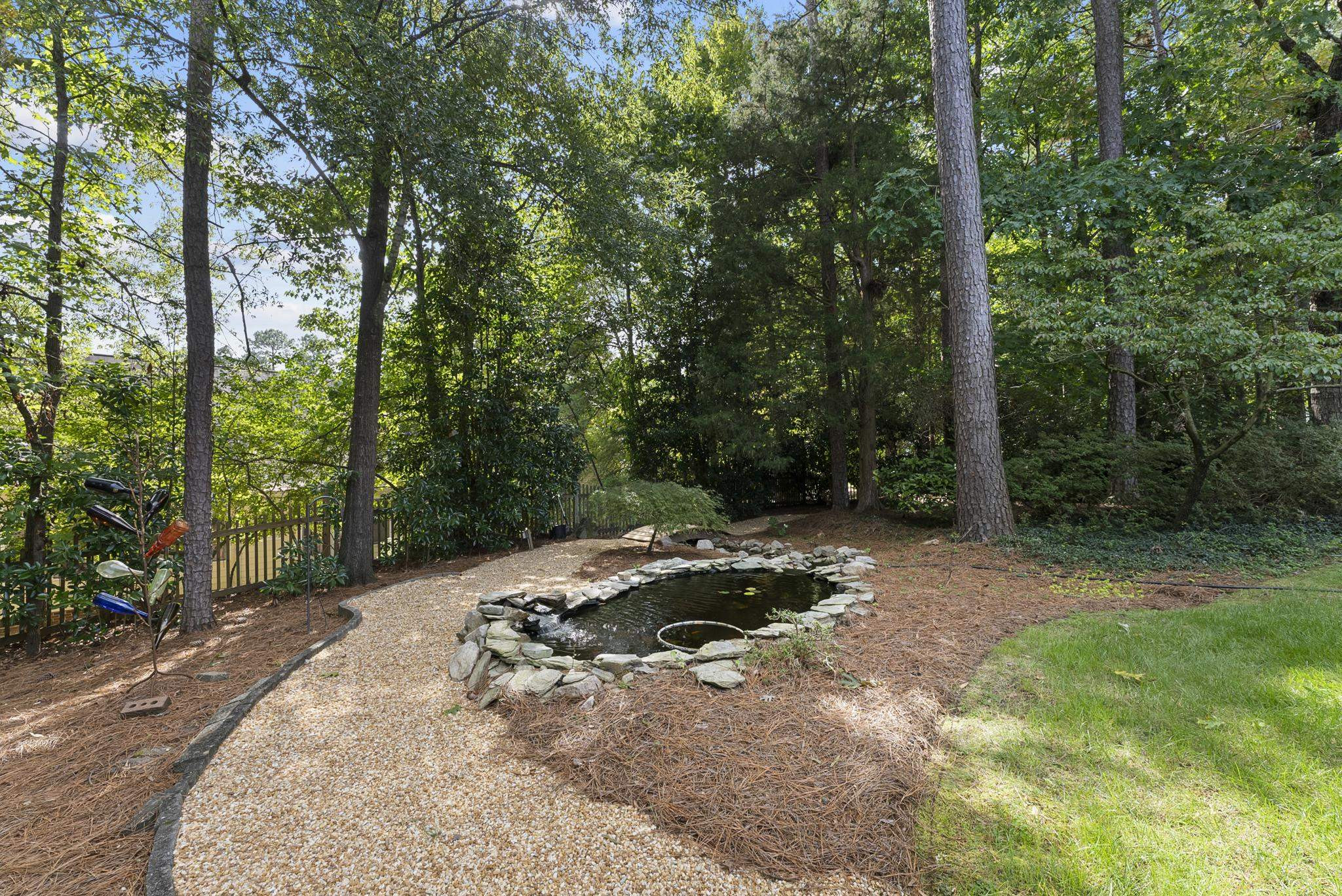 1608 Falls River Avenue Raleigh, NC 27614 - Photo 40 of 65 a wooden bench with trees in the background