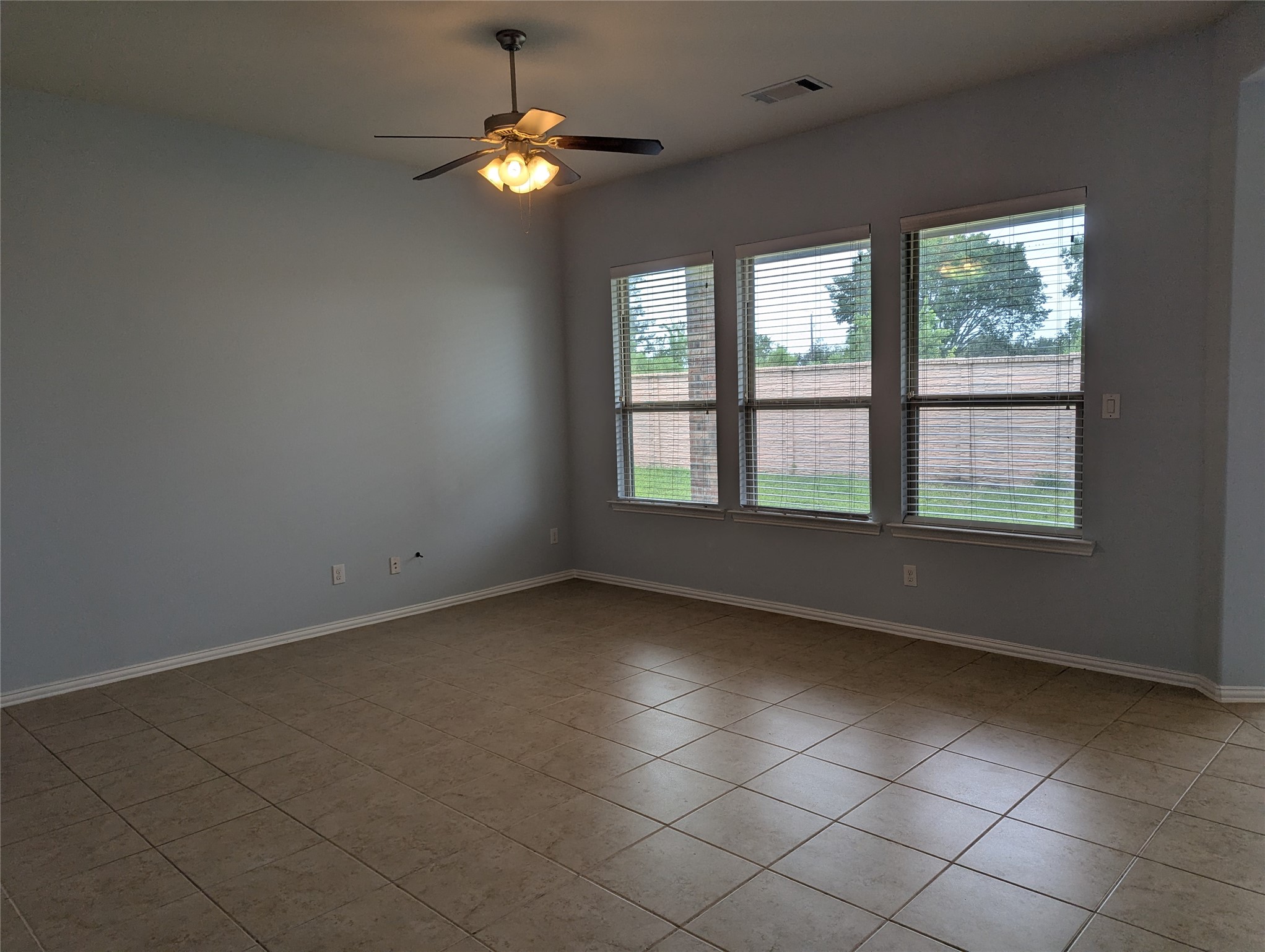 8041 Silent Deep Drive Rosenberg, TX 77469 - Photo 4 of 24 Another view of the family Room: Spacious, sunlit space with elegant tile flooring and large windows, perfect for relaxation and gatherings.