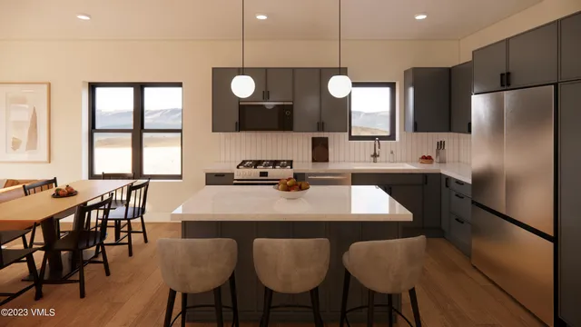 a kitchen with granite countertop a table chairs stove and refrigerator