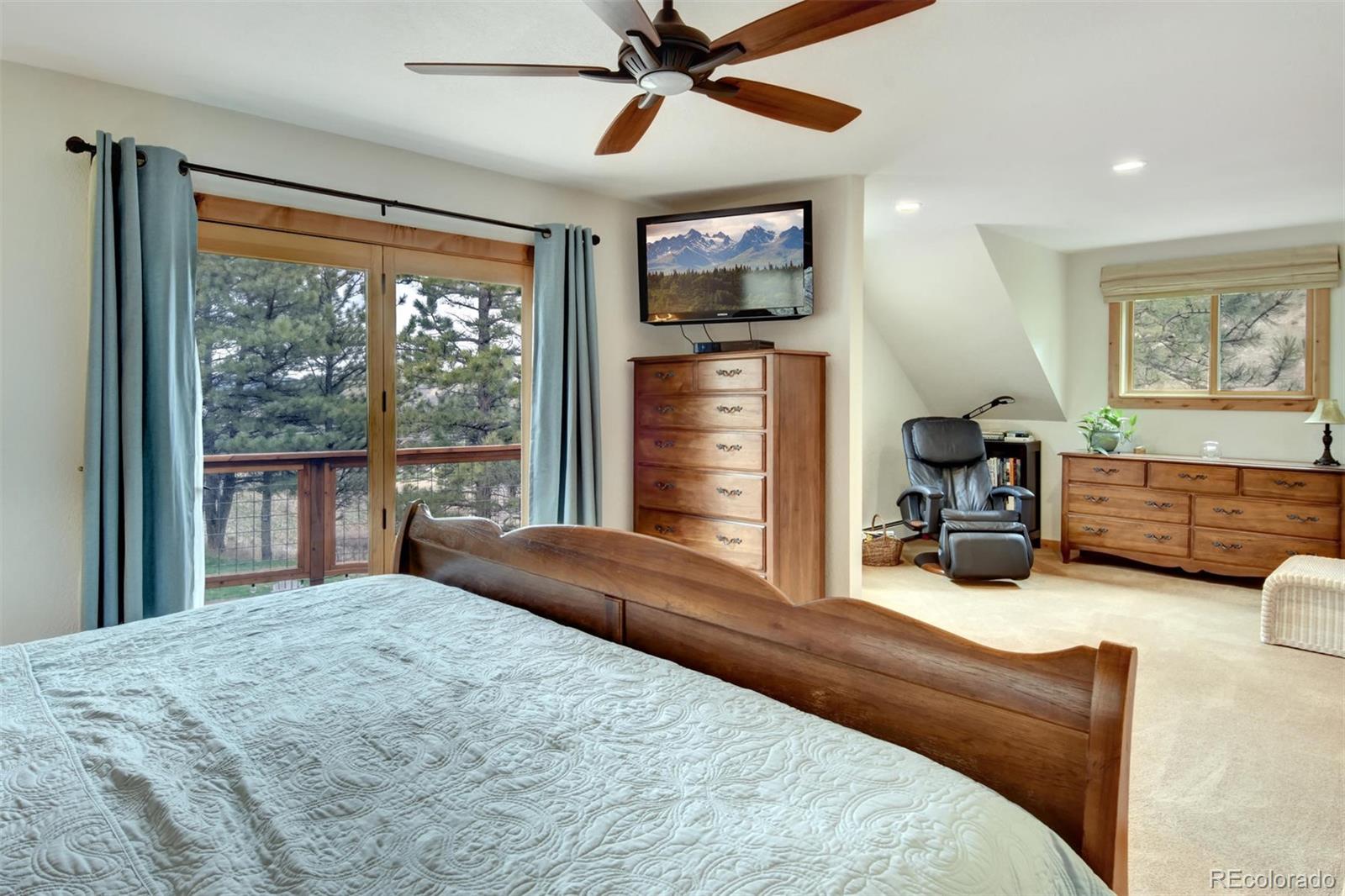 6761 Olde Stage Road Boulder, CO 80302 - Photo 17 of 36 a bedroom with a bed a flat screen tv and a large window
