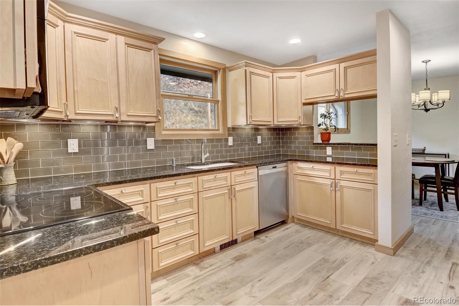 6761 Olde Stage Road Boulder, CO 80302 - Photo 10 of 36 a kitchen with granite countertop white cabinets sink and stainless steel appliances