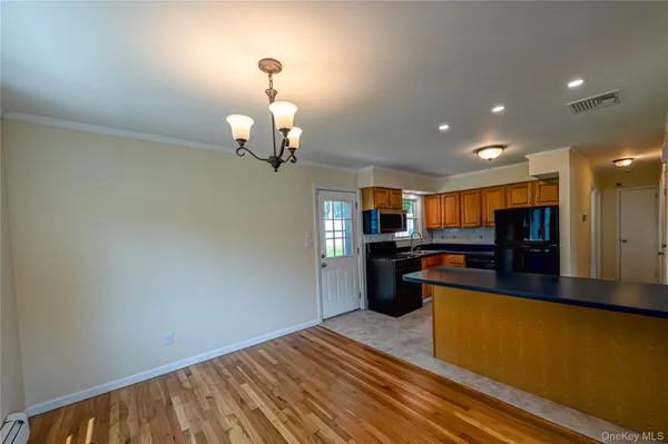 a kitchen with stainless steel appliances kitchen island granite countertop a sink dishwasher stove and oven with wooden floor
