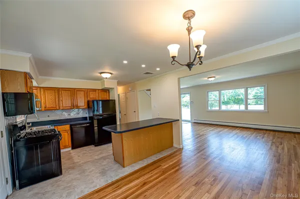 a large kitchen with stainless steel appliances granite countertop a stove and a wooden floors
