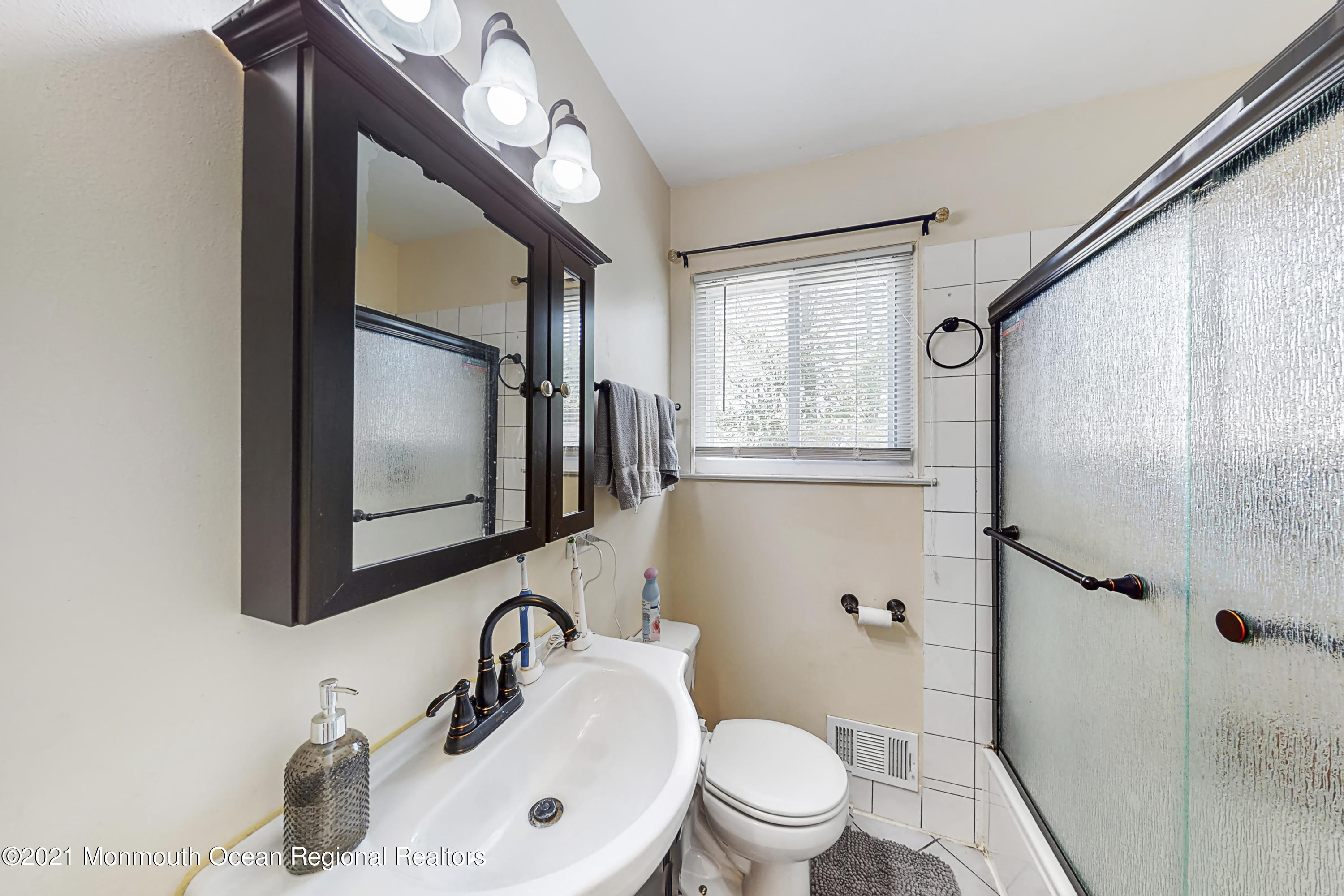 342 Stinson Road Brick, NJ 08723 - Photo 9 of 24 a bathroom with a toilet sink a mirror and shower