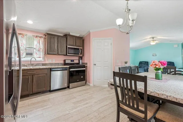 a kitchen with stainless steel appliances granite countertop a kitchen island hardwood floor sink stove dining table and chairs