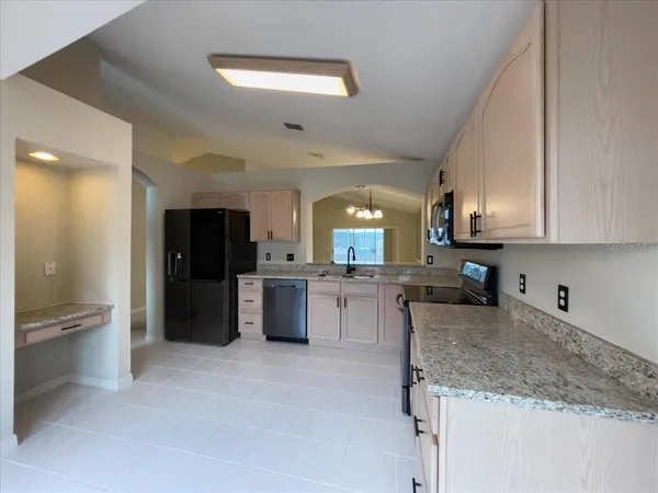 a kitchen with stainless steel appliances granite countertop a sink stove and refrigerator