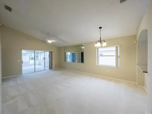 a view of empty room with windows and chandelier