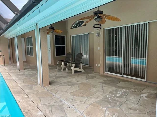 a view of a door with a chairs and table in a patio