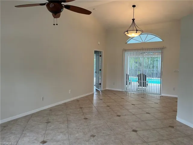a view of a livingroom with a chandelier a ceiling fan and window