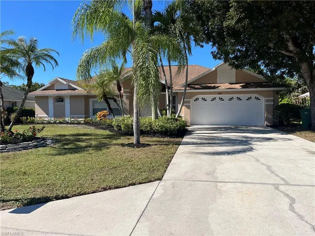 a view of a house with a yard and palm trees