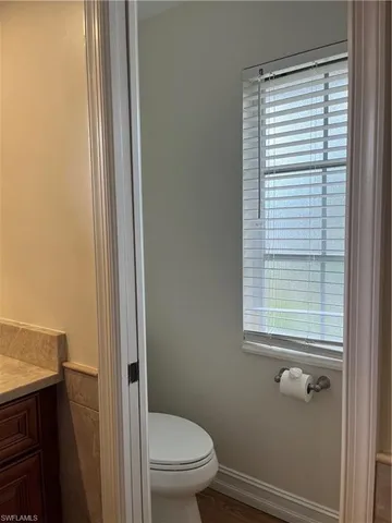 a bathroom with a toilet a sink and a window