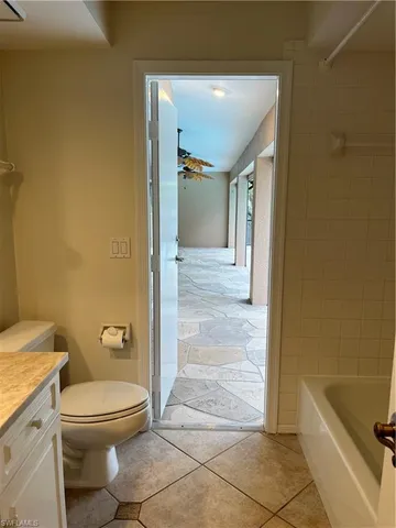 a bathroom with a granite countertop toilet and a shower
