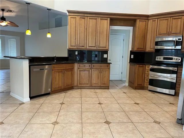 a kitchen with stainless steel appliances granite countertop a stove a sink and a refrigerator