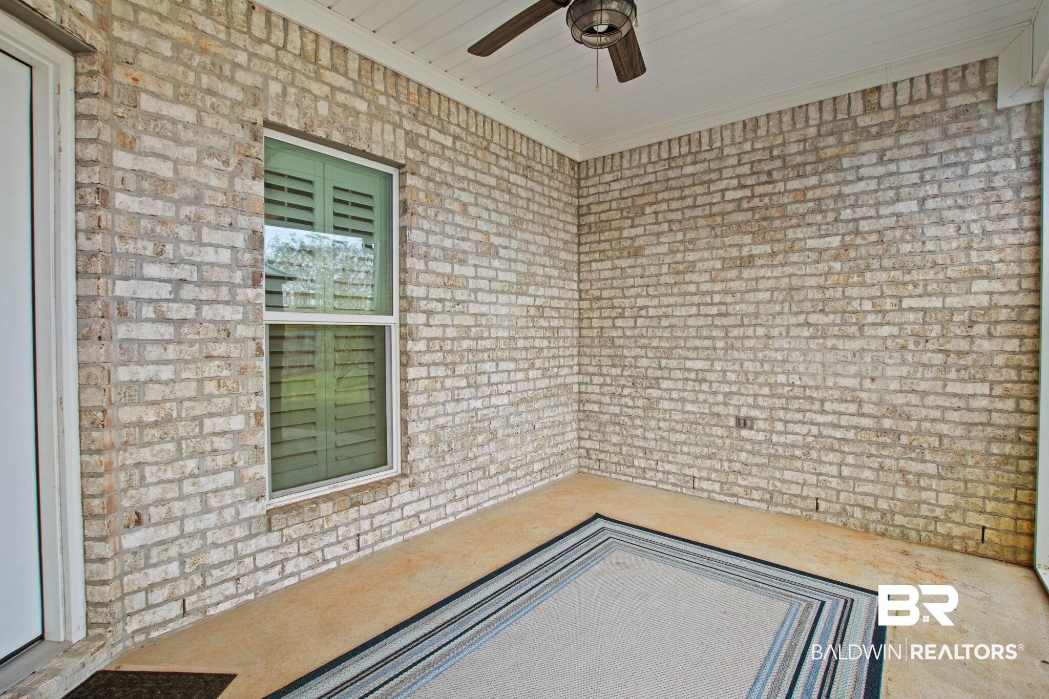17376 Bankhead Boulevard Fairhope, AL 36532 - Photo 67 of 73 Unfurnished room with unfinished concrete floors, brick wall, a ceiling fan, and ornamental molding