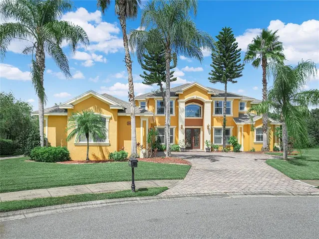 a view of a large white house with a yard and garage