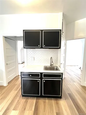 a living room with a flat screen tv and kitchen view