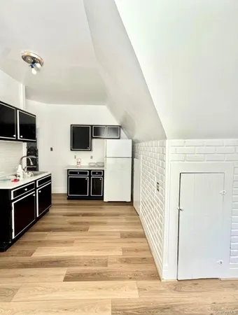 a view wooden floor and kitchen with sink