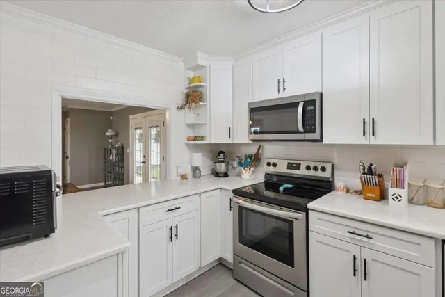 a kitchen with white cabinets and white appliances