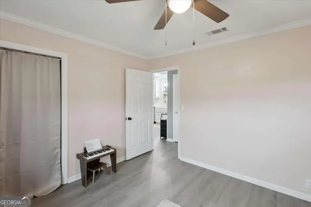 a view of room with wooden floor and ceiling fan