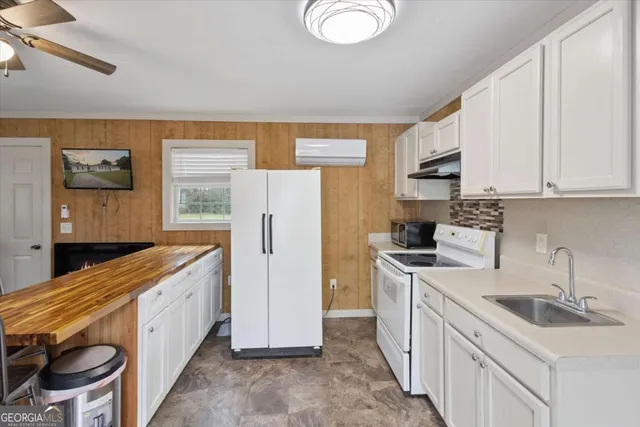 a kitchen with a sink a refrigerator and cabinets